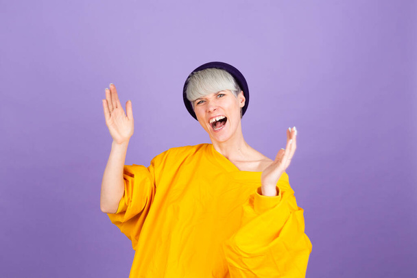 Stylish european woman on purple background clapping and applauding happy and joyful, smiling proud hands together - Photo, Image