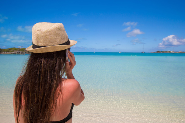młoda kobieta mówi jej telefon na tropikalnej plaży - Zdjęcie, obraz