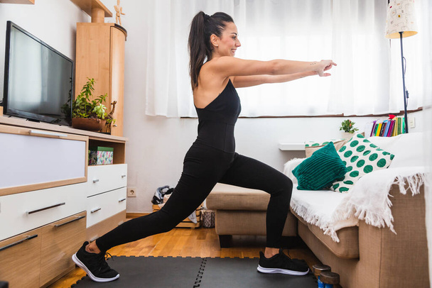Young woman exercising in her small apartment - Photo, Image
