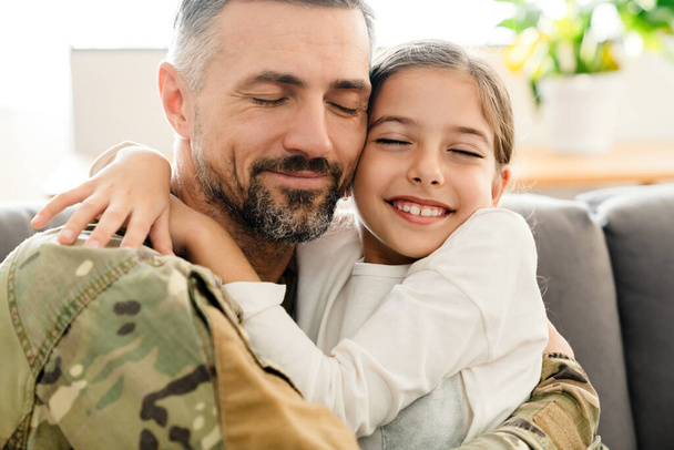 Happy military father and his daughter reunion at home. Family reunion or returning home concept - Fotografie, Obrázek