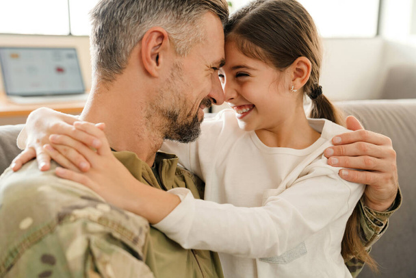 Happy military father and his daughter reunion at home. Family reunion or returning home concept - Photo, image