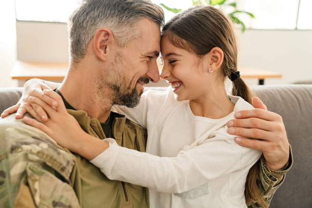 Heureux père militaire et sa fille se réunissent à la maison. Réunion de famille ou concept de retour à la maison - Photo, image