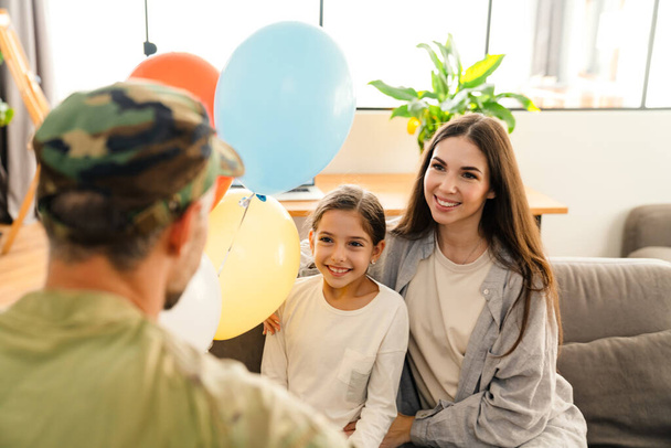 Happy kids and their mom meeting military dad in uniform indoors. Family reunion or returning home concept - Fotoğraf, Görsel