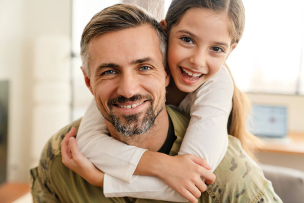 Happy military father and his daughter reunion at home. Family reunion or returning home concept - Fotoğraf, Görsel