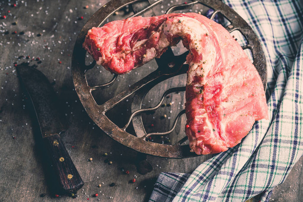 Un primer plano de costillas de cerdo crudas que se cocinan con condimentos - Foto, imagen