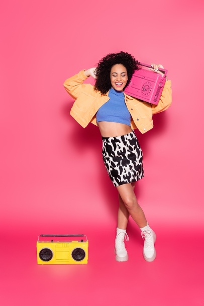 full length of african american woman posing with boombox on pink - Foto, Imagem