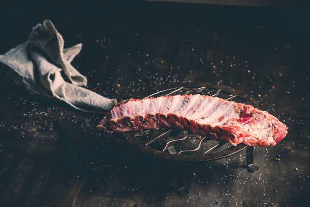 A closeup shot of raw pork ribs being cooked with seasonings - 写真・画像