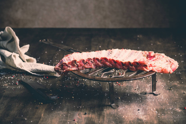 A closeup shot of raw pork ribs being cooked with seasonings - Fotó, kép