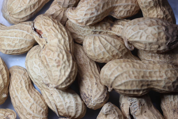 殻付きの皮をむいたピーナッツ。ピーナッツの食物背景 - 写真・画像