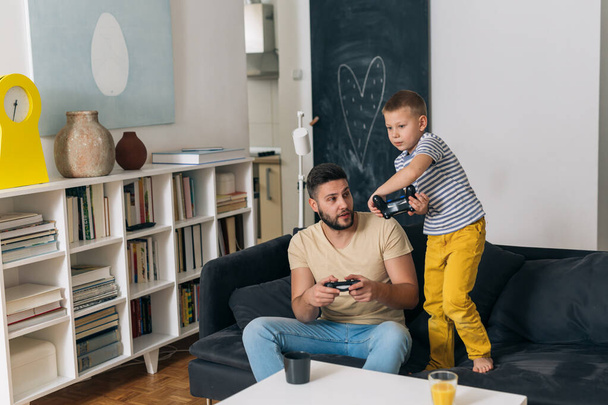 father playing video games with his son at home - Fotografie, Obrázek