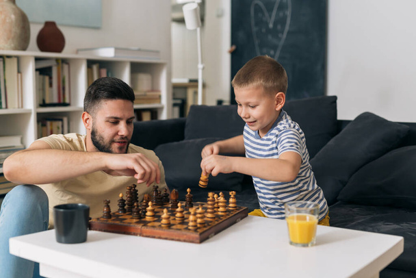 father playing chess with his son at home - Fotografie, Obrázek