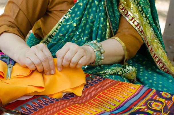 Uma mulher num sari brilhante está a fazer à mão. Mãos femininas foto. - Foto, Imagem