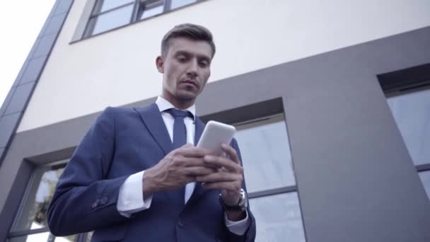 Επιχειρηματίας χαμογελώντας και χρησιμοποιώντας κινητό τηλέφωνο σε εξωτερικούς χώρους  - Πλάνα, βίντεο