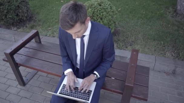 Vista aérea del hombre de negocios utilizando el ordenador portátil en el banco  - Imágenes, Vídeo