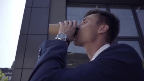 コーヒーを飲みながら外に出てサングラスをかけるビジネスマン  - 映像、動画