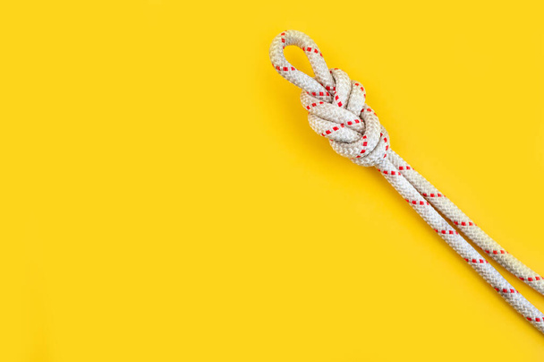 Rope with the Knot eight. Isolated on the yellow background. Minimal concept, copy space. - Fotó, kép