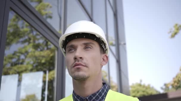 Budowniczy w twardym kapeluszu spaceruje na zewnątrz  - Materiał filmowy, wideo