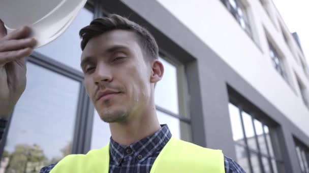 Bauarbeiter in Warnweste mit hartem Hut im Freien - Filmmaterial, Video