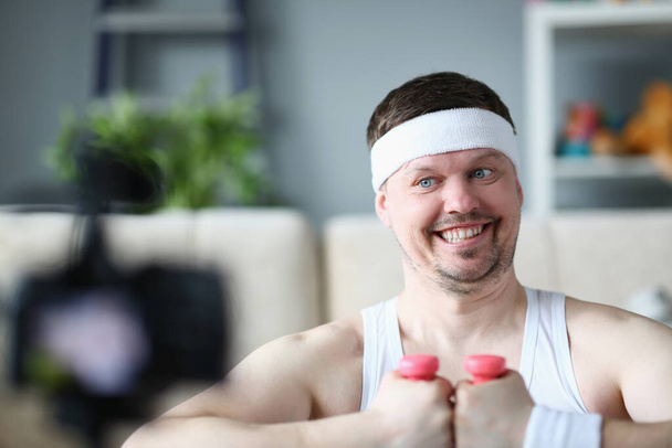 Usmívající se muž blogger nahrávání fyzické cvičení na kameru - Fotografie, Obrázek