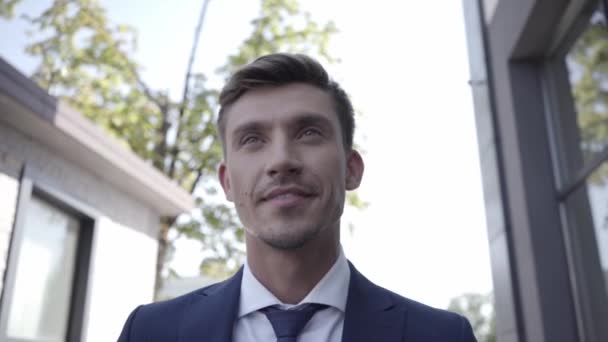 Glimlachende zakenman met papieren beker die buiten loopt  - Video