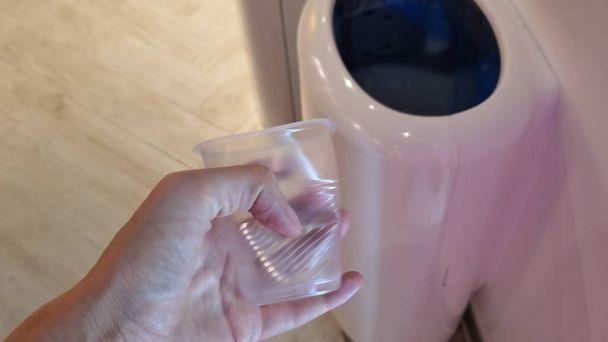 POV розчавити і кинути одноразову пластикову чашку в сміттєву банку
 - Фото, зображення