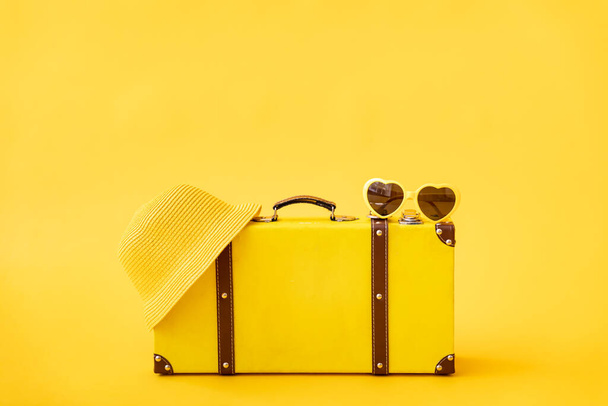 黄色の背景にヴィンテージスーツケース。夏休みと旅行のコンセプト - 写真・画像