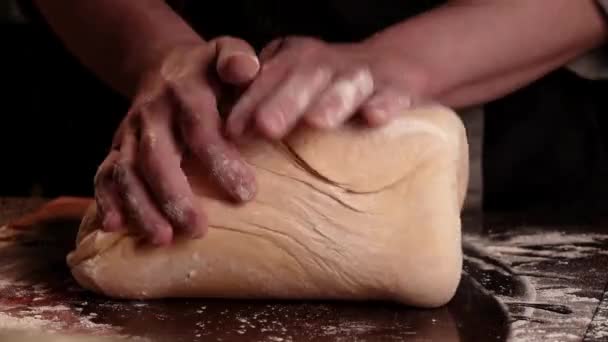 Baker chef kneading floured dough for bread in homemade bakery. Dark atmosphere. Space for text.  - Footage, Video