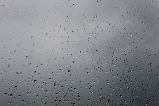 曇った背景の窓に雨の滴. - 写真・画像