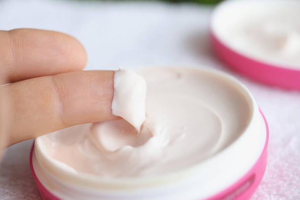 Crème cosmétique naturelle blanche sur les doigts gros plan - Photo, image