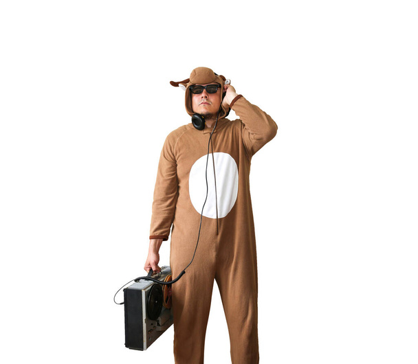 Muž v kostýmovém kostýmu krávy s magnetofonem. Chlápek ve zvířecím pyžamu. Vtipná fotka s nápady na párty. Disco retro hudba. - Fotografie, Obrázek
