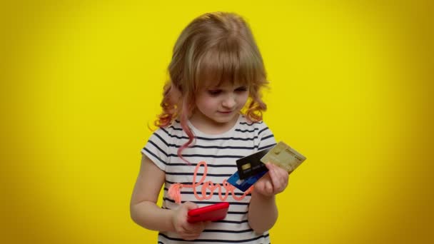 Dítě holka použít mobilní telefon a plastové kreditní karty, prohlížení říct wow ano, skvělé vítězství - Záběry, video