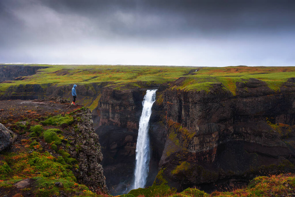 Wanderer am Rande des Haifoss-Wasserfalls in Island - Foto, Bild