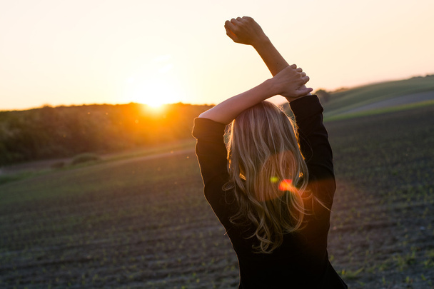 νεαρή γυναίκα απολαμβάνει τις ακτίνες του ήλιου - Φωτογραφία, εικόνα