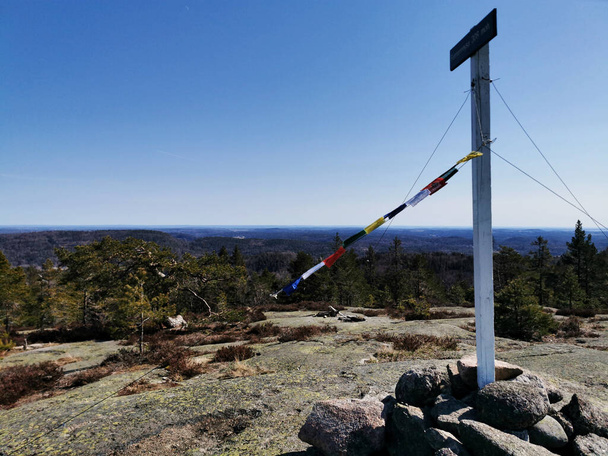 A large pole with banners on a rocky field on Farmenroysa Hill in Vestfold, Norway - Фото, изображение