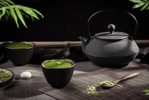 Matcha-Teepulver und Tee-Accessoires auf dunklem Hintergrund. Teezeremonie. Traditionelles japanisches Getränk. - Foto, Bild