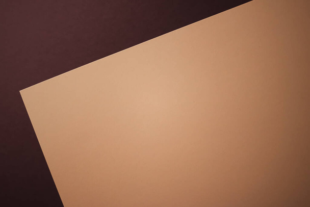 Пустая бумага формата А4, бежевый цвет на темном фоне как офисная канцелярская бумага, роскошный дизайн бренда и дизайн фирменного стиля для макета - Фото, изображение