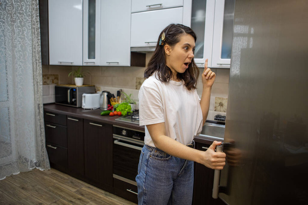 vrouw geopend koelkast denken wat te koken kopieerruimte - Foto, afbeelding