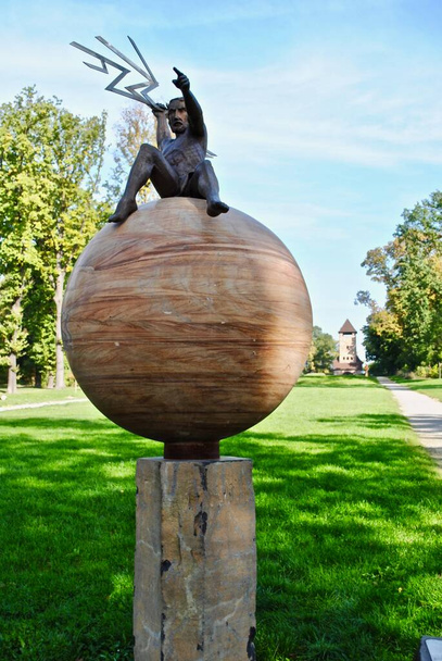 Bad Nauheim, Germania: Giove, dio del tuono, siede sul pianeta lanciando fulmini a Goldsteinpark. Planet Trail (PlanetenWanderweg) è un percorso di 2 km con sculture raffiguranti i pianeti. - Foto, immagini