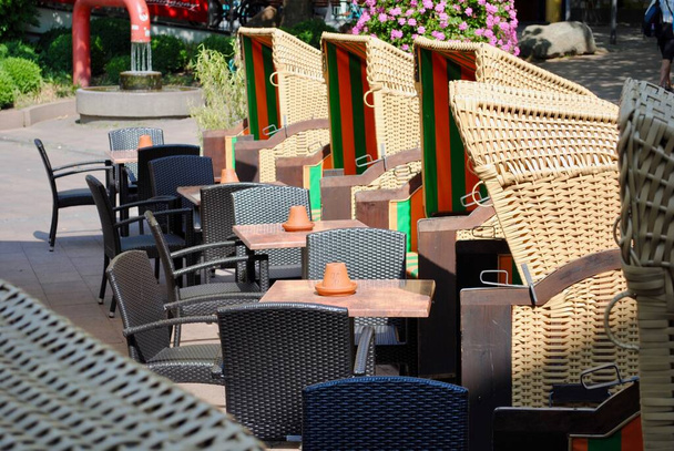 Sedie da spiaggia tedesche chiamate Strandkorb in un ristorante all'aperto a Kiel, Germania. Queste sedie tradizionali sono un oggetto di Gemtlichkeit tedesco e si possono trovare nelle città balneari della Germania settentrionale.  - Foto, immagini