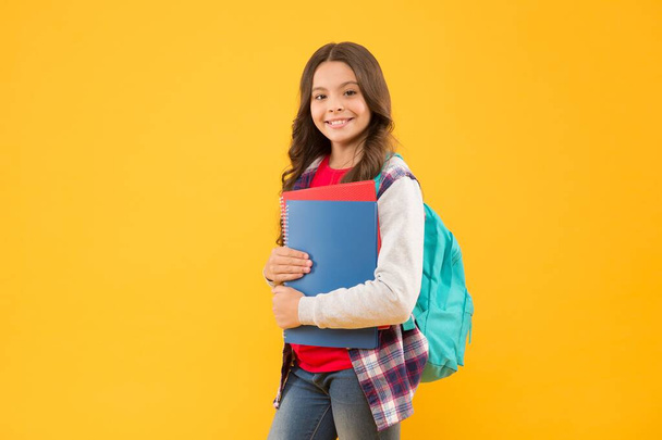 Happy school child hold study books on September 1 yellow background, back to school - Foto, Imagen