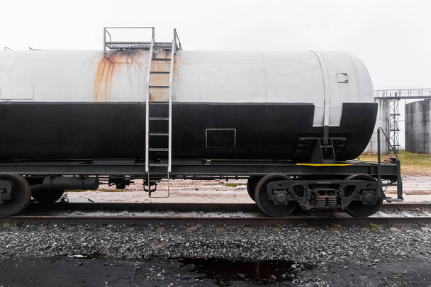 Schmutziger Eisenbahnkesselwagen mit Düngemitteln oder chemischen Produkten nach dem Entladen in einer Industrieanlage. - Foto, Bild