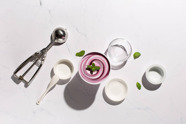 Homemade yogurt vanilla blueberry ice cream and fresh mint on natural stone marble background. Healthy low calorie summer dessert food concept. Top view, copy space. Hard sun shadows. - 写真・画像