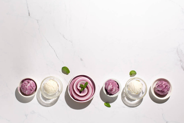 Domowej roboty jogurt waniliowy lodów jagodowych i świeżej mięty na naturalnym tle marmuru kamiennego. Zdrowa, niskokaloryczna, letnia koncepcja jedzenia deserowego. Widok z góry, odbiór. Twarde cienie słońca. - Zdjęcie, obraz