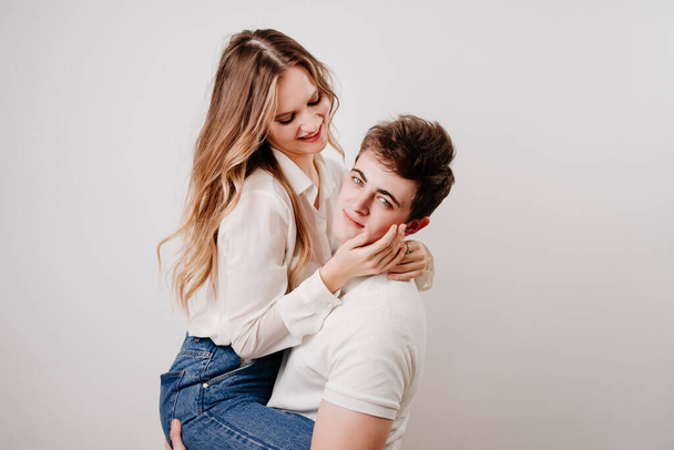 love, passionate and beautiful couple have fun and cuddle against the white wall - Foto, Imagem