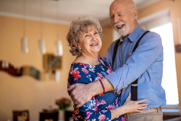 Happy senior couple dancing together at home - Фото, зображення