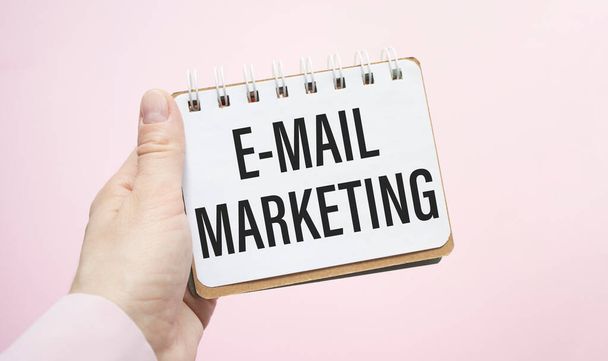 E-mail marketing Wpisany na białym papierze z ręką na różowym tle - Zdjęcie, obraz