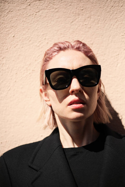 Vertical portrait of young woman with pinkish hair, wearing sunglasses. - Foto, Imagem