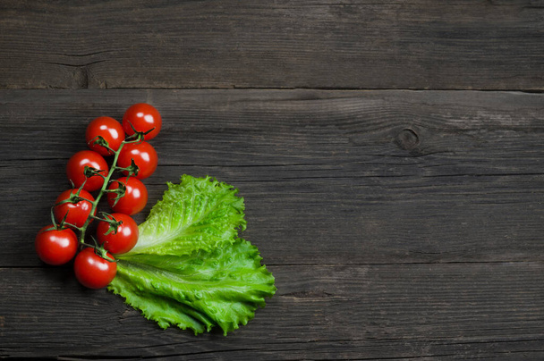 Ripe delicious red cherry tomatoes bunch on wooden background - Foto, afbeelding