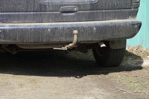 one gray iron towbar on a black dirty rear bumper of a car on the street - Photo, Image