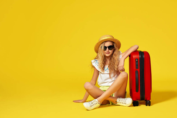 excited little girl with suitcase and passport sitting on floor - Valokuva, kuva